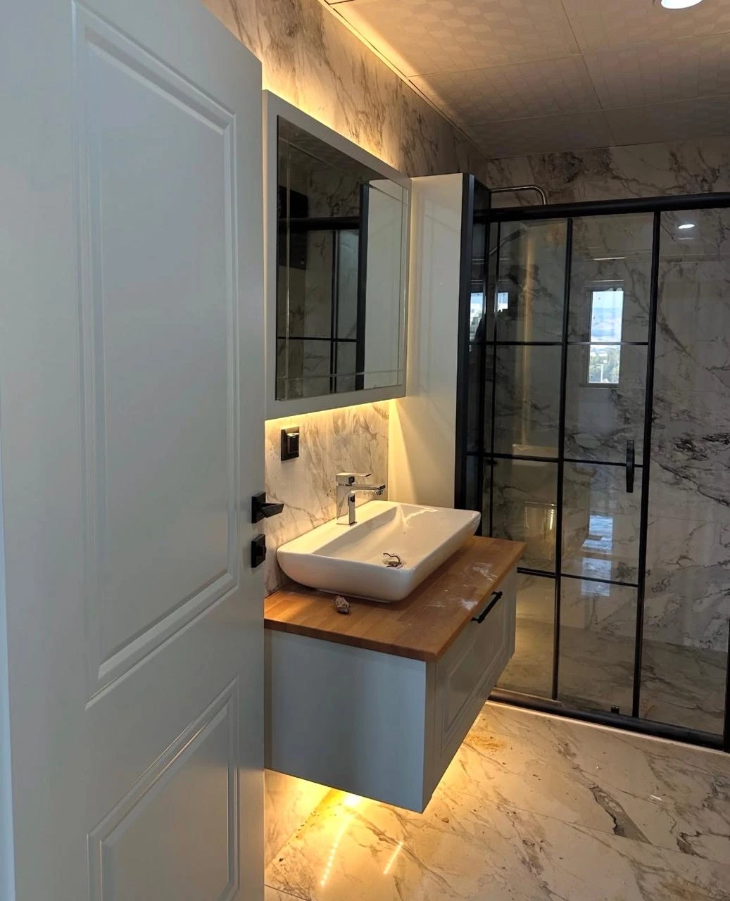 Baño con iluminación integrada en una obra realizada