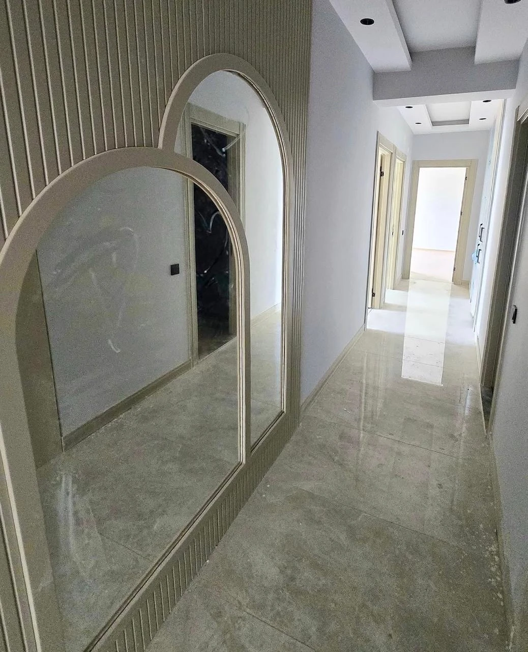 Pasillo con espejos y revestimiento decorativo